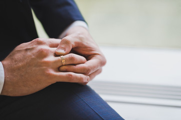 Mens hands are adjusting their wedding rings 1493.