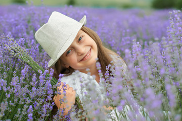 Fototapeta premium child girl is in the lavender field, beautiful portrait, face closeup, summer landscape