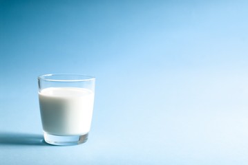 Obraz na płótnie Canvas Glass of milk on blue background
