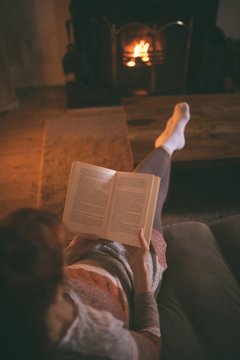 Woman reading a book in living room