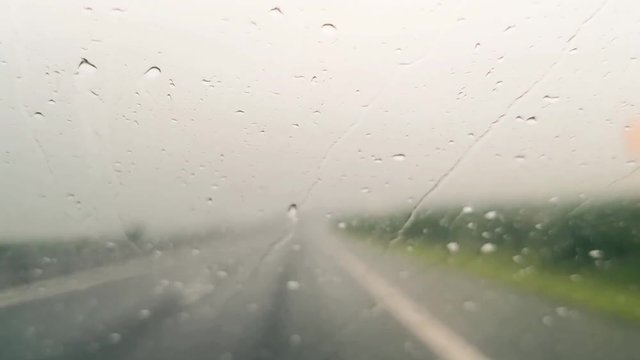 Footage of a car's wind screen, driving through the rain. 