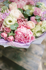 Beautiful summer bouquet. Arrangement with mix flowers. Flower bunch with peony on wooden table. The concept of a flower shop. Content for the catalog