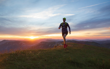 Athlete trail running in Massif du Vercors during sunset. Shallow D.O.F. and with motion blur.