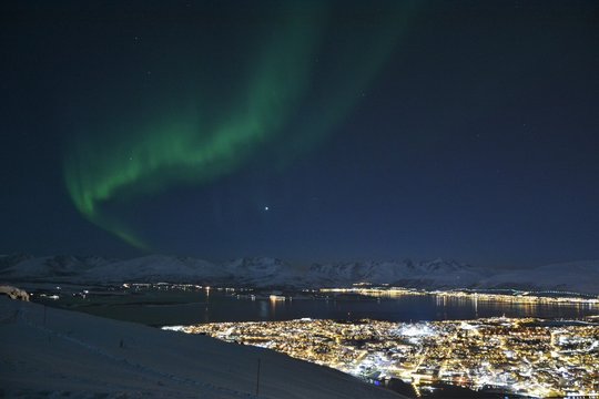 The northern lights (Aurora Borealis) and the city scape from Fjellheisen Peak over the city 