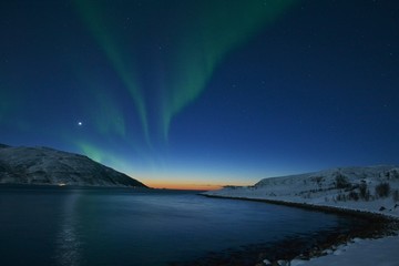 Naklejka na ściany i meble The northern lights (Aurora Borealis) over Seljelvnes, Troms by the sea and the snowy mountains