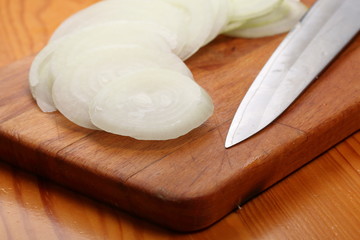 Fototapeta na wymiar Sliced onions and knife lie on a cutting board