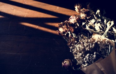 Fototapeta na wymiar Closeup of dry flowers bouquet on wooden floor