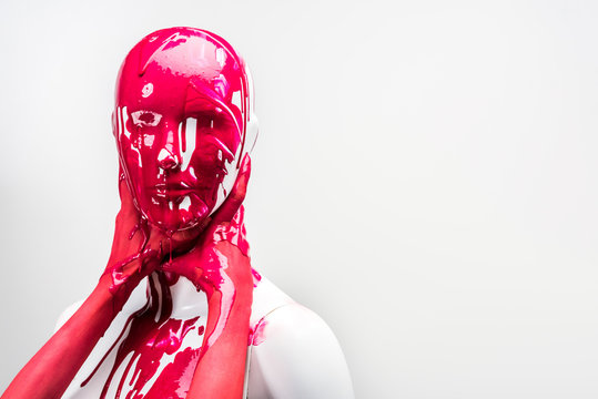 cropped image of girl in red paint touching mannequin neck with hands isolated on white