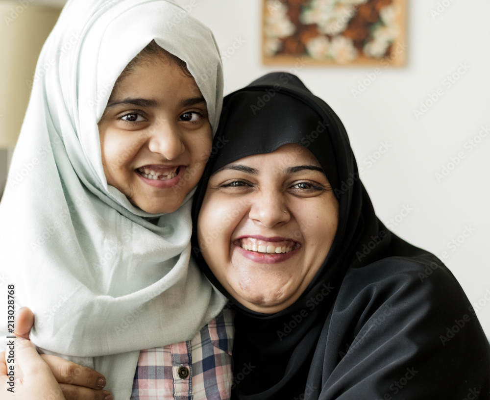 Wall mural smiling portrait of a muslim mother and a daughter