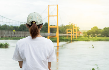 a woman looking at a suspension bridge