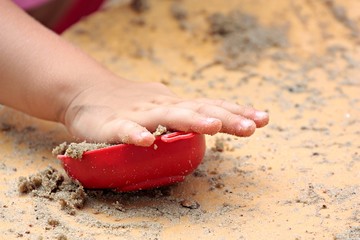 dziecko bawi się foremką w piasku na plaży  - obrazy, fototapety, plakaty