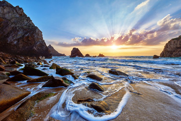Sand beach among rocks on evening sunset. Ursa near Cape Roca