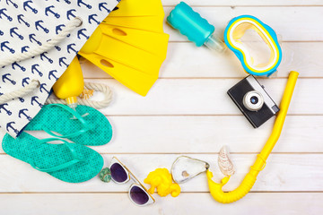 Beachwear and accessories on a white wooden background
