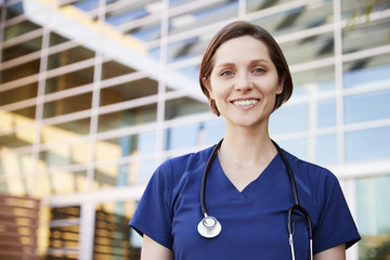 Smiling white female healthcare worker outdoors, portrait