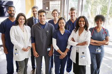 Team of healthcare workers at a hospital smiling to camera - Powered by Adobe