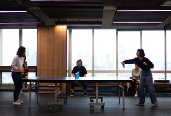 Fototapeta na wymiar Girls is playing table tennis at the office.