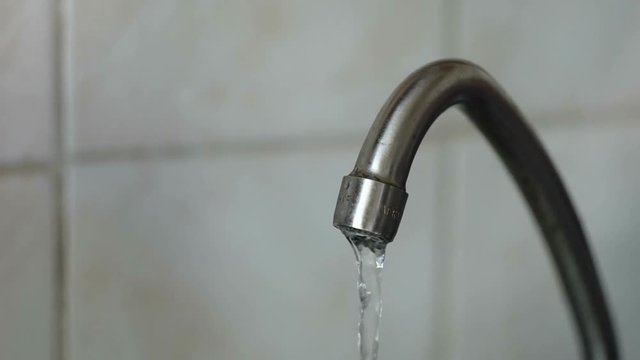 Water under weak pressure flows from a water tap