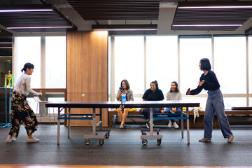 Girls is playing table tennis at the office. - obrazy, fototapety, plakaty