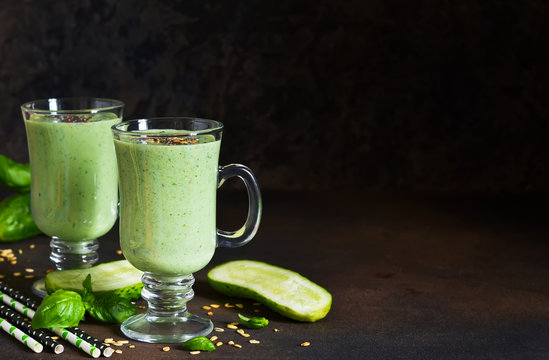 Green smoothies with avocado, cucumber, basil and granola on a dark stony background. Dietary drink.