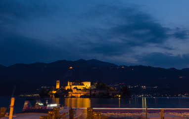 Fototapeta na wymiar night transit of a tourist boat in front of the island of San Giulio, Italy