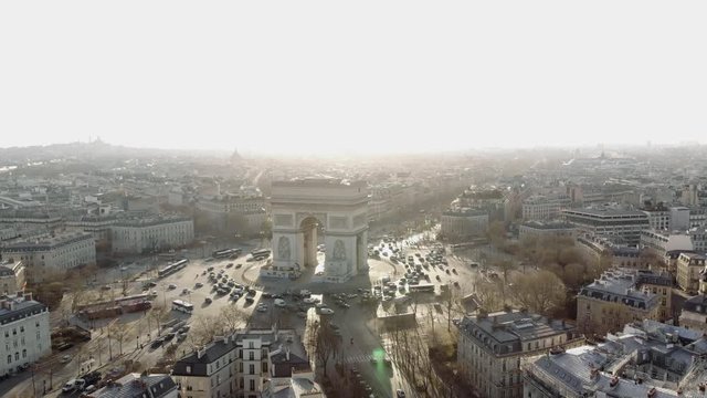The Arc de Triomphe in morning light. The sun paints Paris in heavenly light. The camera sinks from the sky into the streets of Paris.
