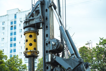 Drilling rig boring hole in city at construction site