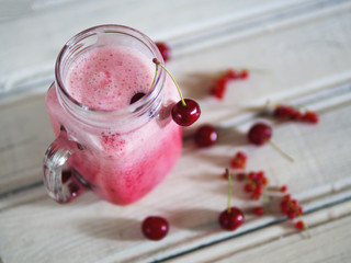 Cherry refreshing cocktail or smoothie on wooden table top view