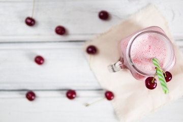 Cherry refreshing cocktail or smoothie on wooden table top view