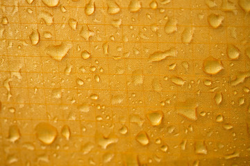 yellow waterproof material, rip stop cloth with drops of water background