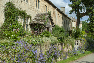 Fototapeta na wymiar Summer time view of cotswold cottage with half timbered porch, summer flowers and lavender with a rustic stone facade near Iford Manor, Iford near Bradford Upon Avon, Wiltshire, UK