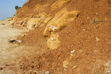 the surface texture of the slope from dry sand-clay granular soils with a reddish tinge