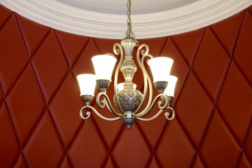 luxury chandelier with the interior design decoration red colour wall with a pattern.