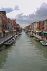 Classic view along side canal on Venice showing 3 storey houses either side of a working canal, Venice, Italy
