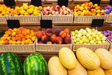 Fresh fruits in wicker baskets on the counter of a small vegetable market. 