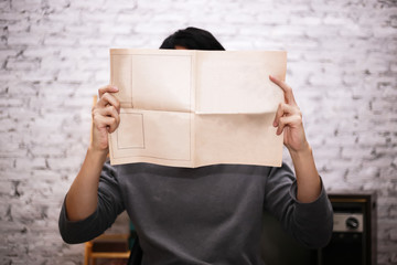 Young businessman holding an empty mockup newspaper - ready to insert any text onto publication paper.
