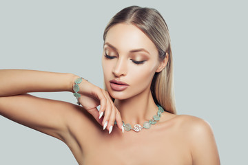 Beautiful Female Face Closeup. Glamorous Fashion Model Woman in Jewelry Necklace and Bracelet. Blonde Hair, Makeup and Accessories