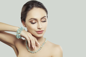 Glamorous Woman Fashion Model with Makeup and Jewelry. Gold Necklace and Bracelet with Semiprecious...