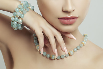 Perfect jewelry on female body, closeup portrait. Bracelet, necklace and manicure