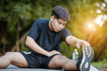 Sporty man stretching and warming up legs for running fitness  workout. Sport and healthy lifestyle concept. Man exercising outside.