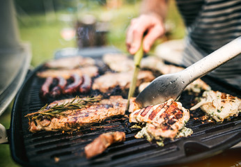 Unrecognizable man cooking seafood on a barbecue grill in the backyard. Close up. - obrazy, fototapety, plakaty