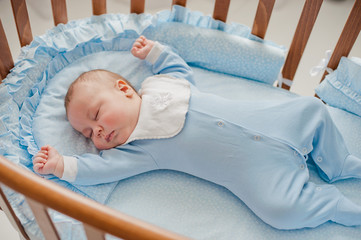 Baby's restful sleep. Newborn baby in a wooden crib. The baby sleeps in the bedside cradle. Safe...