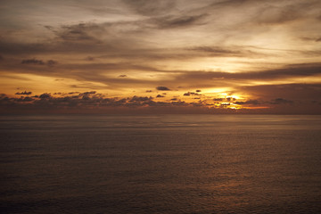 Fototapeta premium Sunset in Bali. Calm sea in the evening. Clouds in the evening sky.