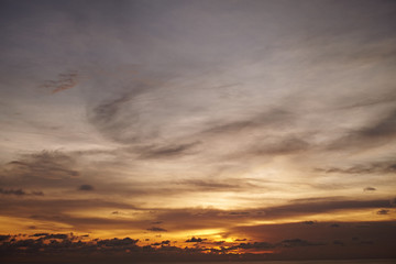 Fototapeta na wymiar Sunset in Bali. Calm sea in the evening. Clouds in the evening sky.