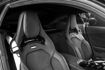 Modern Luxury sport car inside. Interior of prestige car. Black Leather seats with yellow stitching. Black perforated leather. Car interior details. Automatic Transmission. Gear lever. Black and white