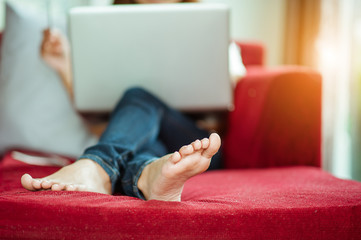 Woman Relaxing On Sofa At Home Using Laptop.copy space,