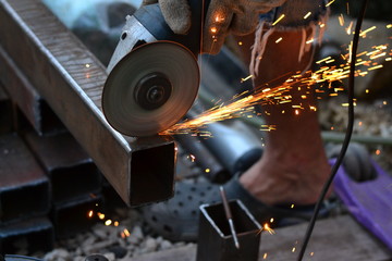 The worker saws the Bulgarian with sparks