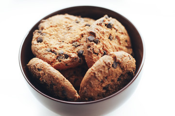 Chocolate cookies in a brown bowl on a white background