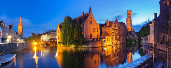 Scenic cityscape with tower Belfort and Church of Our Lady from the quay Rosary, Rozenhoedkaai, at night in Bruges, Belgium