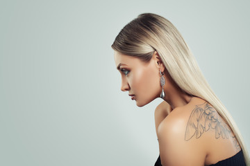 Fototapeta premium Woman with Healthy Blonde Hairstyle, Makeup and Black Pearls Earrings on Background with Copy space