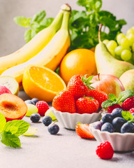 Fresh assorted fruits and berries on light gray background. Colorful clean and healthy eating. Detox food. Retro style toned.